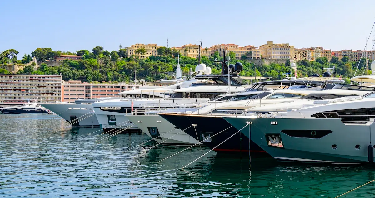 Shot of yachts and superyachts moored in La Condamine habrour, with Monte Carlo in the background.
