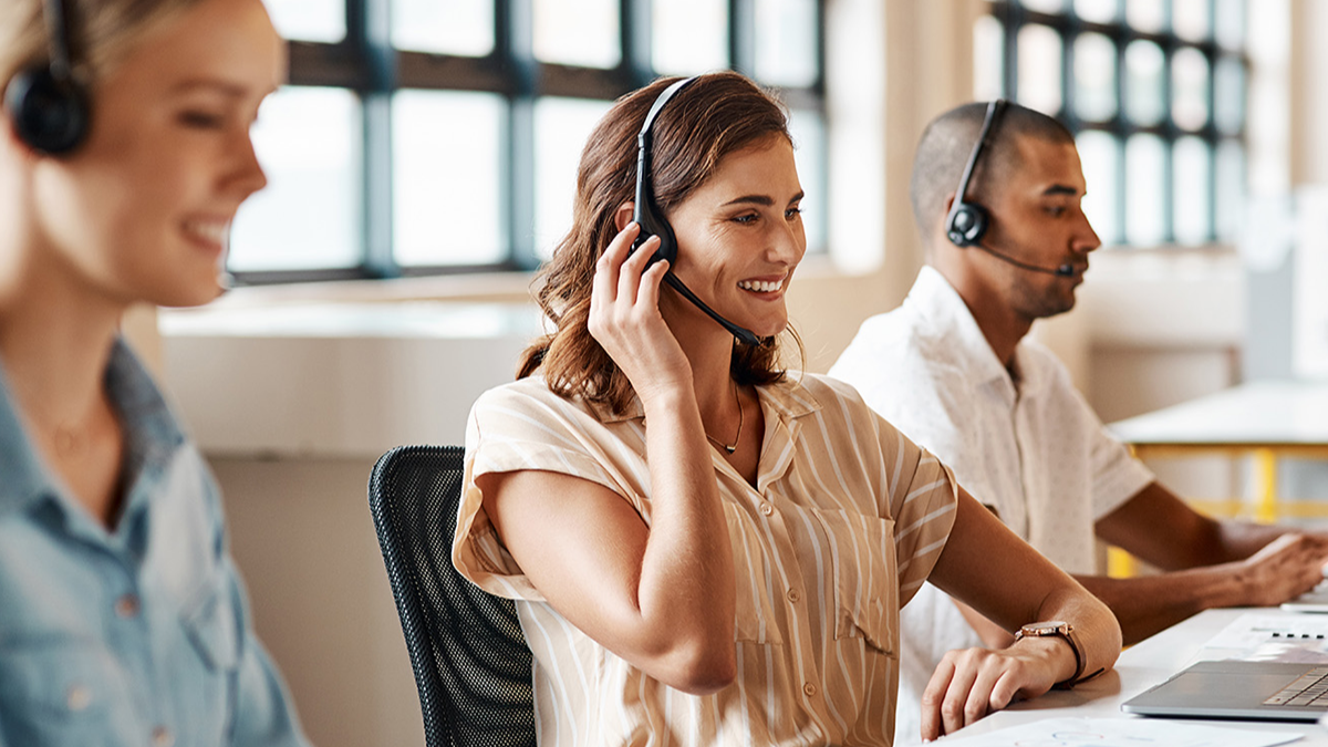 Three people working with headphones with microphones.