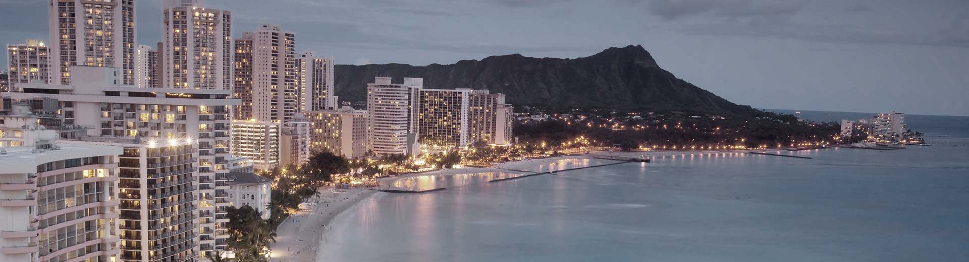 The beautiful coast of Honolulu with tall white hotels in the foreground.