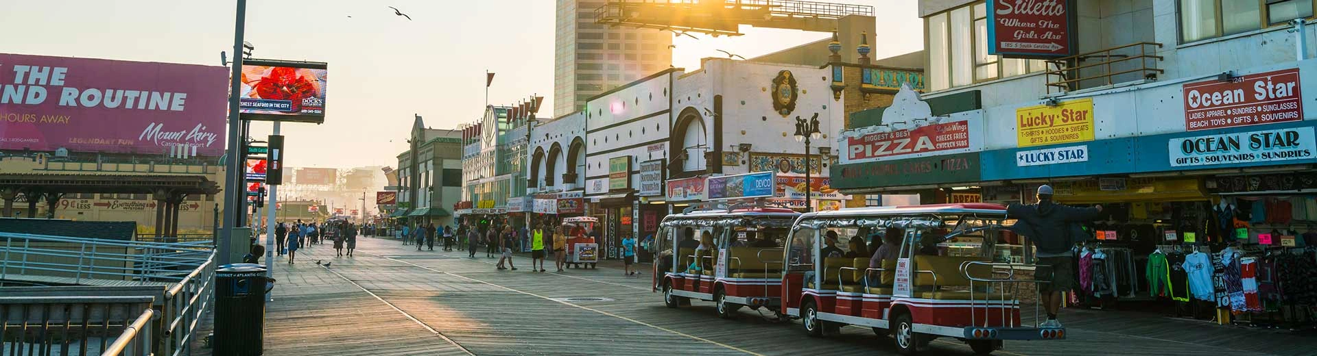 Visitors walk the historic Atlantic City boardwalk lined with shops and restaurants.
