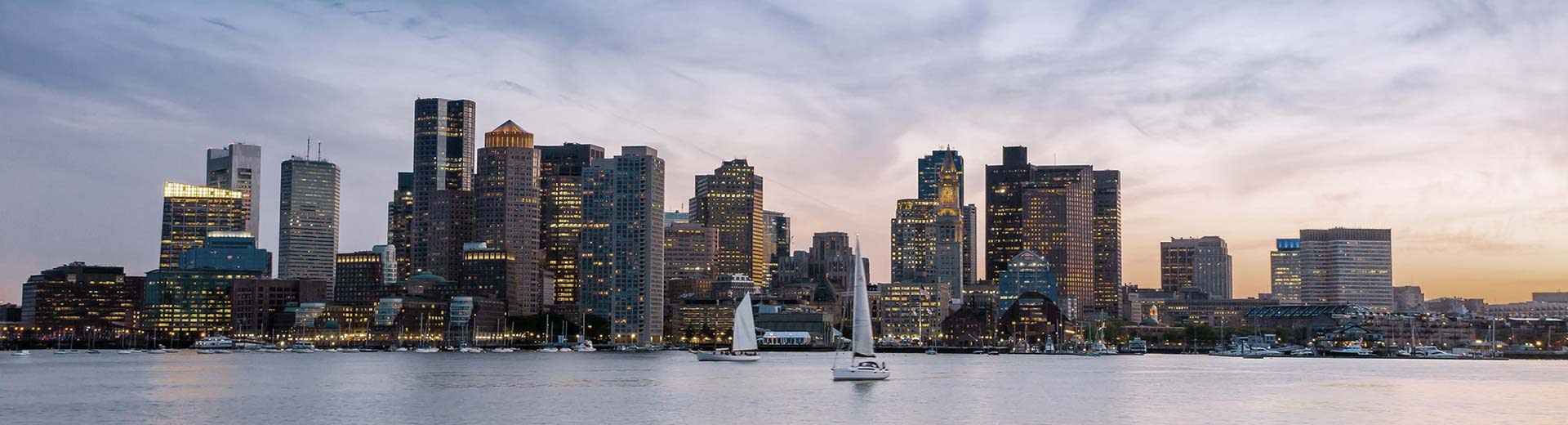 Panorama shot of the Boston business center at sunset from across the harbor.