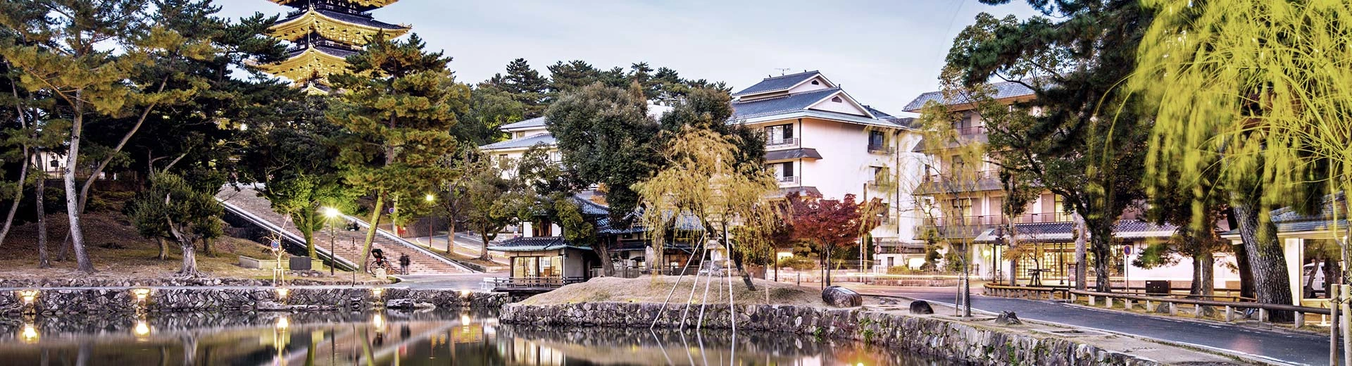 A traditional temply building in the background of Nara, with a small lake in front.