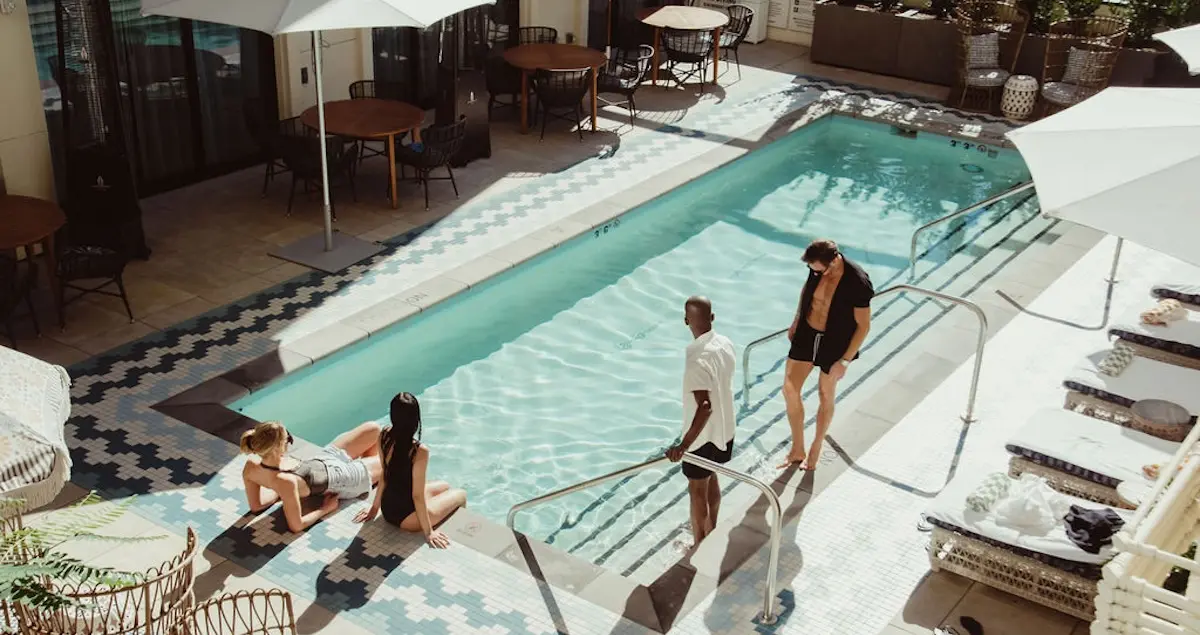 Two men and two women lounge by the outdoor pool in The Aster private members' club in Los Angeles.