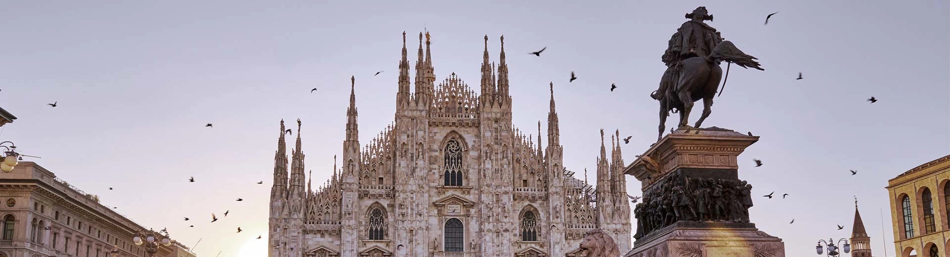 The beautiful cathedral of Milan, with the sun setting in the background.