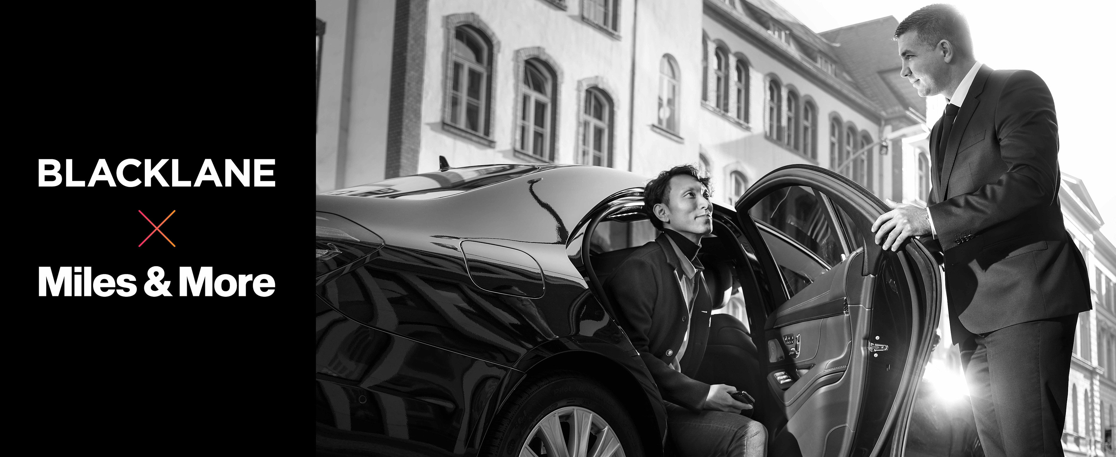 A chauffeur opens the door for a guest exiting the backseat of his Mercedes.