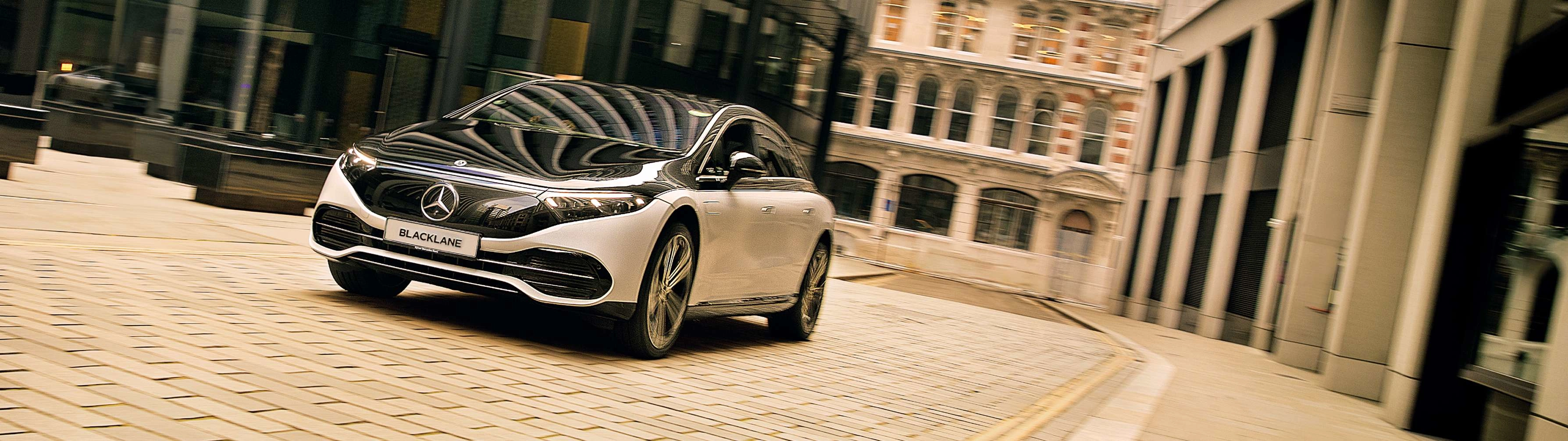 A chauffeured Mercedes EQS from Blacklane drives through London's financial district.