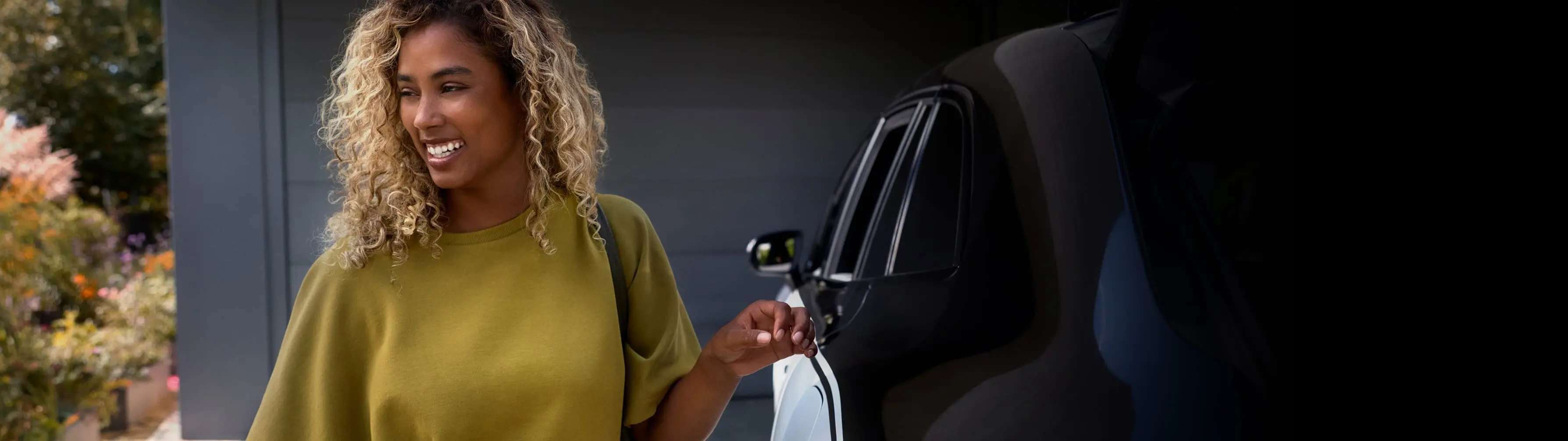 A woman smiles after getting out of a Blacklane limousine service.