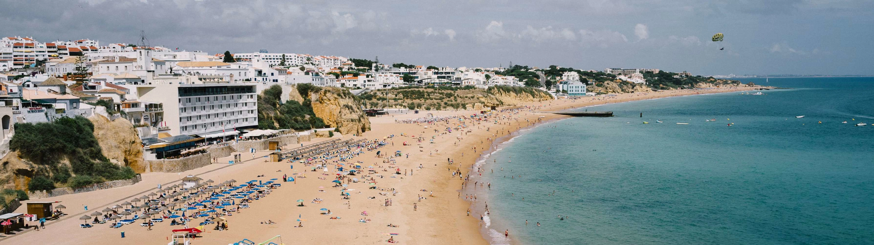 The beautiful white sands of Albufeira next to turqoise waters on a clear summer's day.