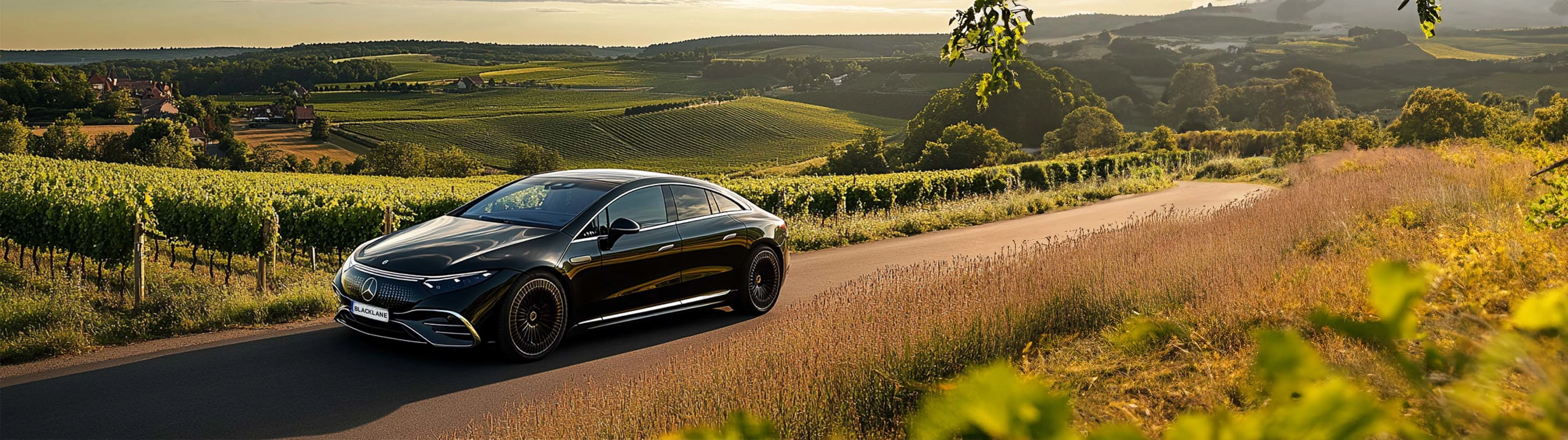 A Blacklane Mercedes limo travels past vineyards on a Beaune wine tour.