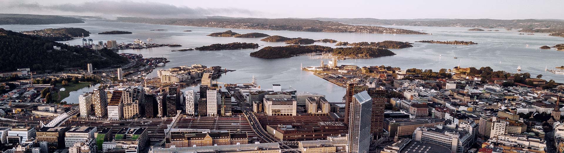 The tall buildings of Oslo overlook the coast of Norway on a cold and clear day.