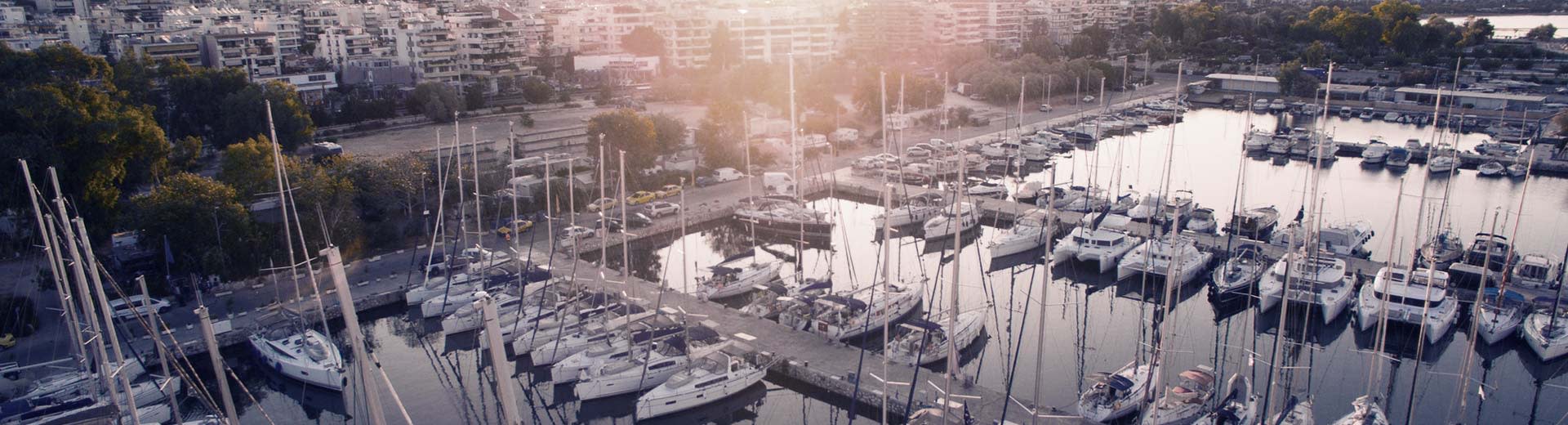 En un puerto en Pireo, varios yates privados acuestan en un día caluroso y despejado.