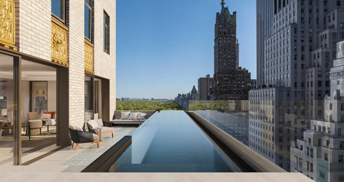 The terrace shot of an apartment in Aman New York private member's club, showing a swimming pool and Central Park in the background.