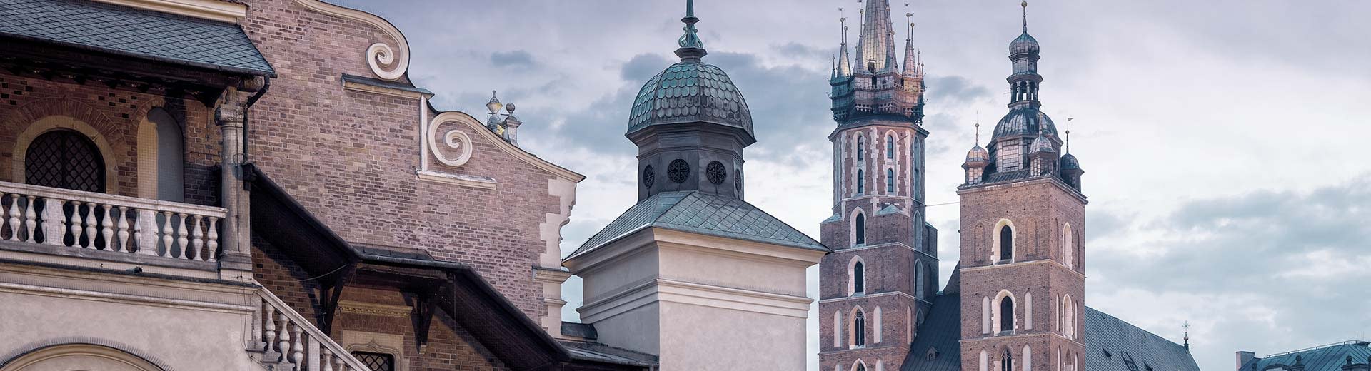 Beautiful Polish churches set against a cloudy sky in Krakow.