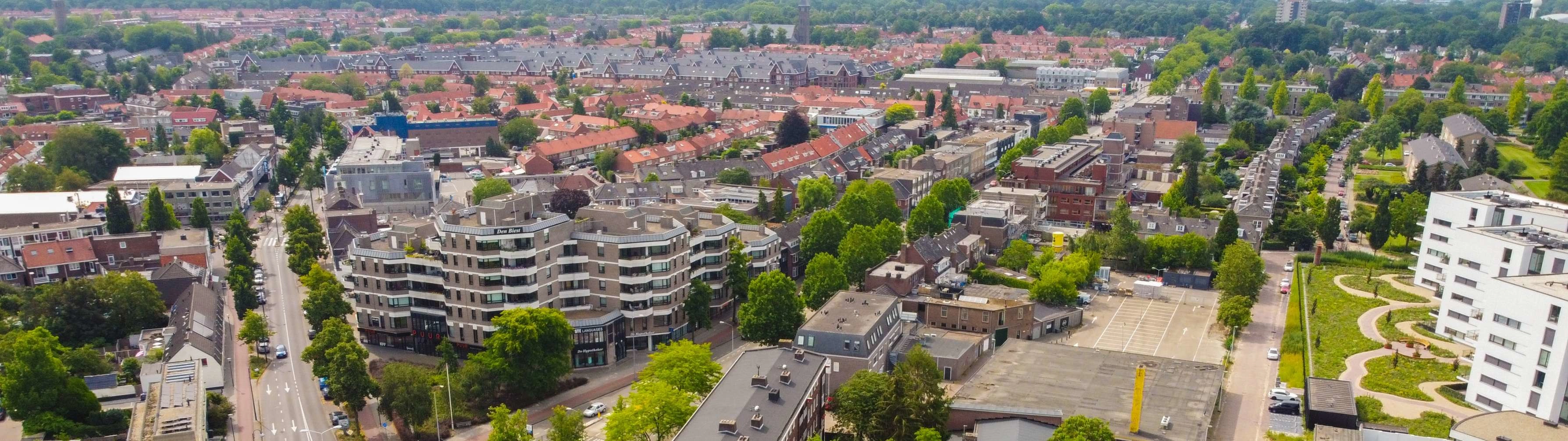 Housing and apartments next to green parks in Eindhoven on a clear day.