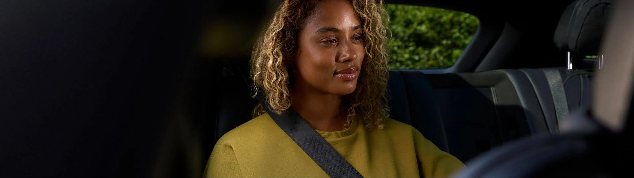 A woman relaxes in the back seat of her Blacklane limousine service.