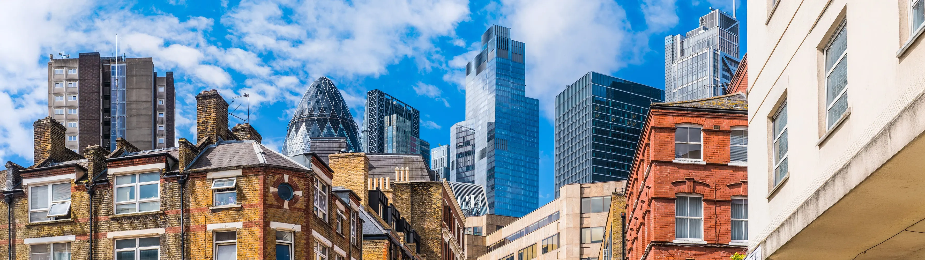 The top of the Gherkin and other skyscrapers and the building tops of London's Shoreditch district.