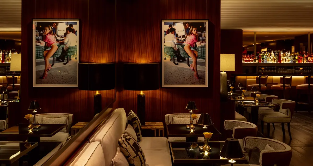 Interior shot of The Lounge in Casa Tua NYC private members' club, showing banquettes, soft lighting, and a well-stocked bar in the background.