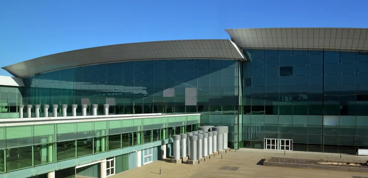 Exterior shot of the Terminal 1 building at Barcelona El Prat Airport on a sunny day.