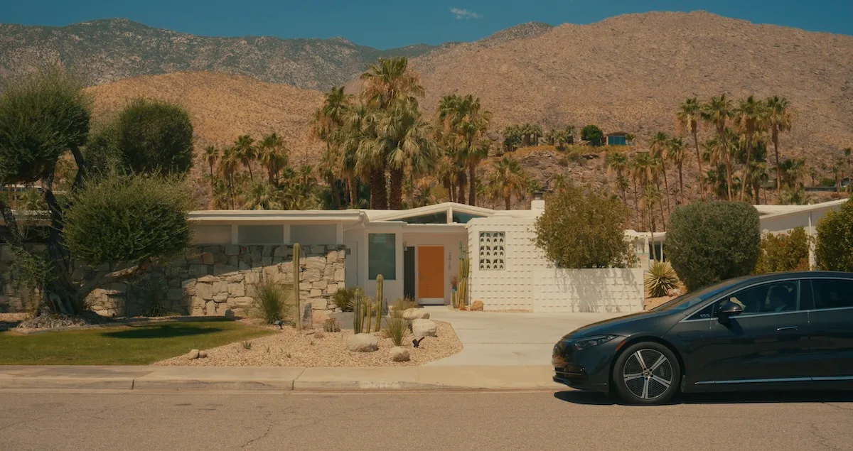 A Blacklane Mercedes limousine sits outside a modern house in California, with palm trees in the background.