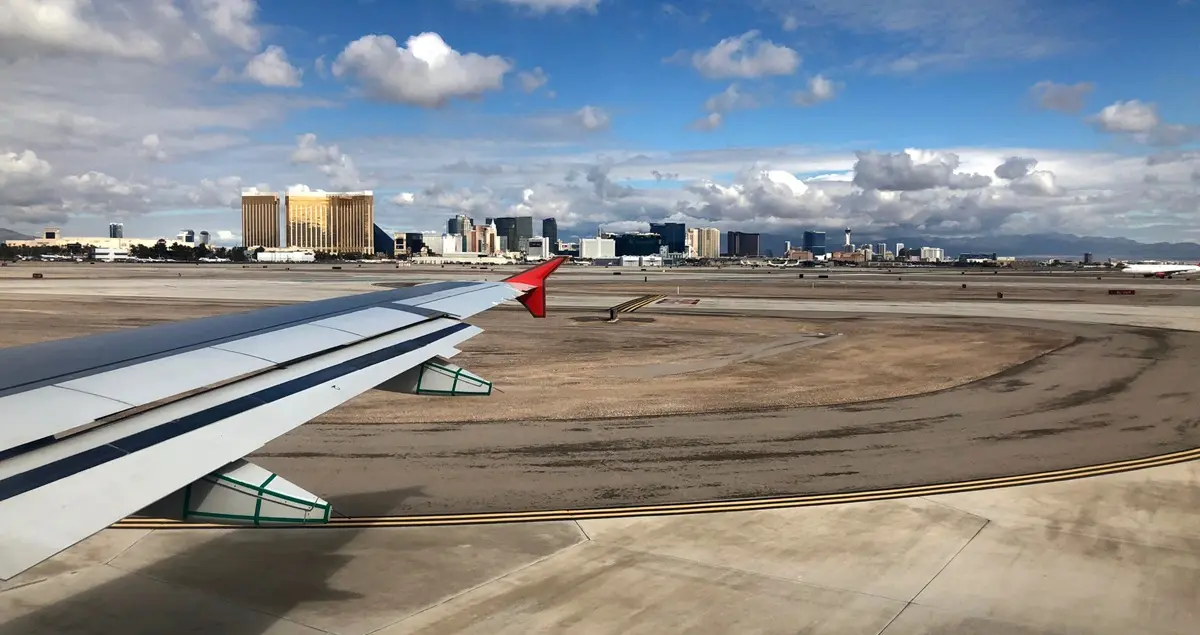 Shot out of the window of an airplane at Las Vegas MCO airport showing the hotels of the Strip in the background, prominently the Mandalay Bay Hotel.