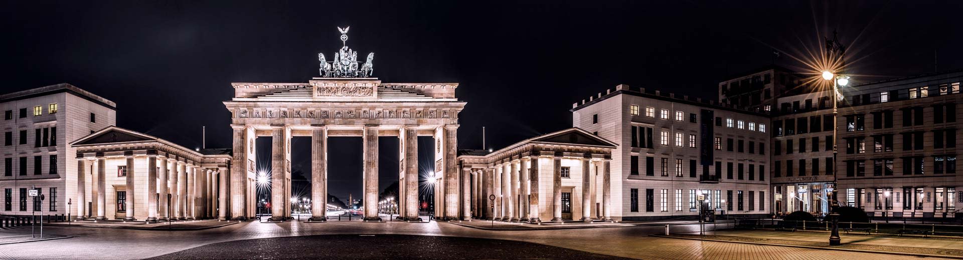 Brandenburg Gate in Berlin at night, with the lights illuminating the structure.