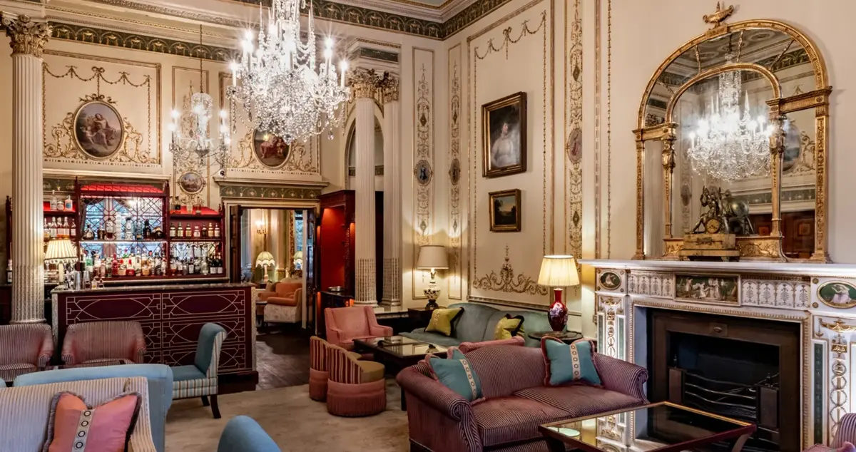 Interior view of one of the drawing rooms in Home House private member's club in London, showing a chandelier and mirroring.