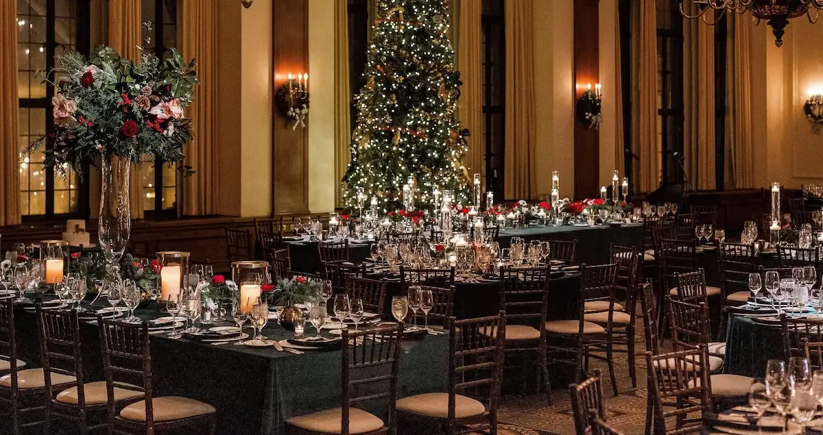 A dining room fully set in the Chicago Club for a festive feast, with a Christmas tree and huge flower arrangements.