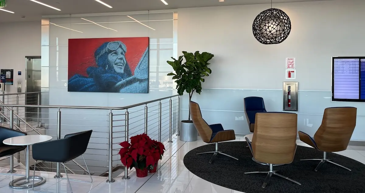 Interior shot of the Delta Sky Club SFO lounge in Terminal 1, showing comfortable chairs, tasteful art, and a flight board.