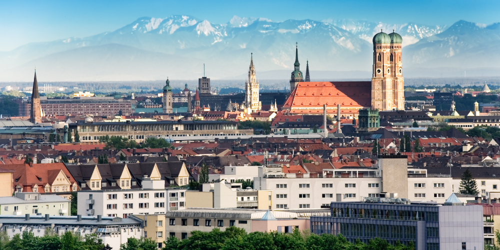 Panoramic view of Munich with the Alps in the background, featuring the Frauenkirche and the historic city center, not far from Munich Airport.