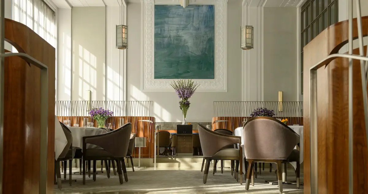 Shot of the empty private dining room at 11 Madison Park in NYC, showing sunlight through high windows and wall art.