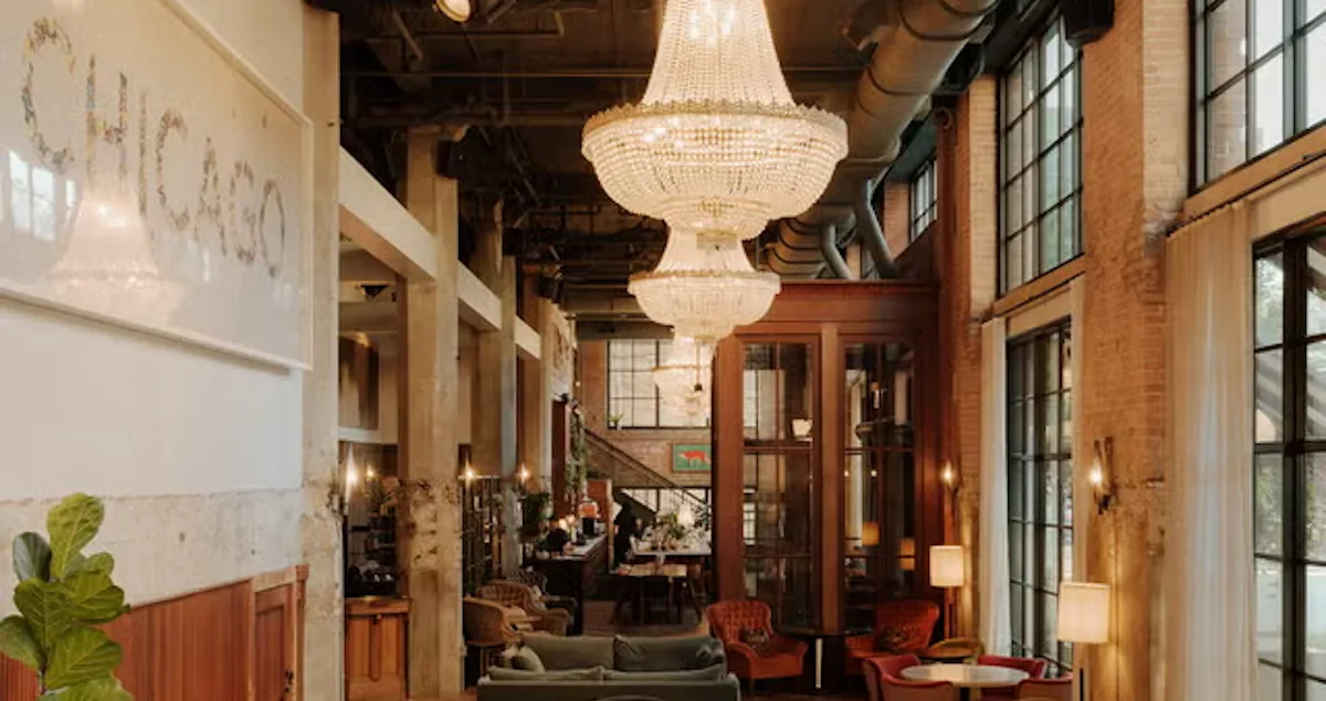 One of the ornate drawing rooms in Soho House Chicago, showing a chandelier, tiled wall, and furniture.