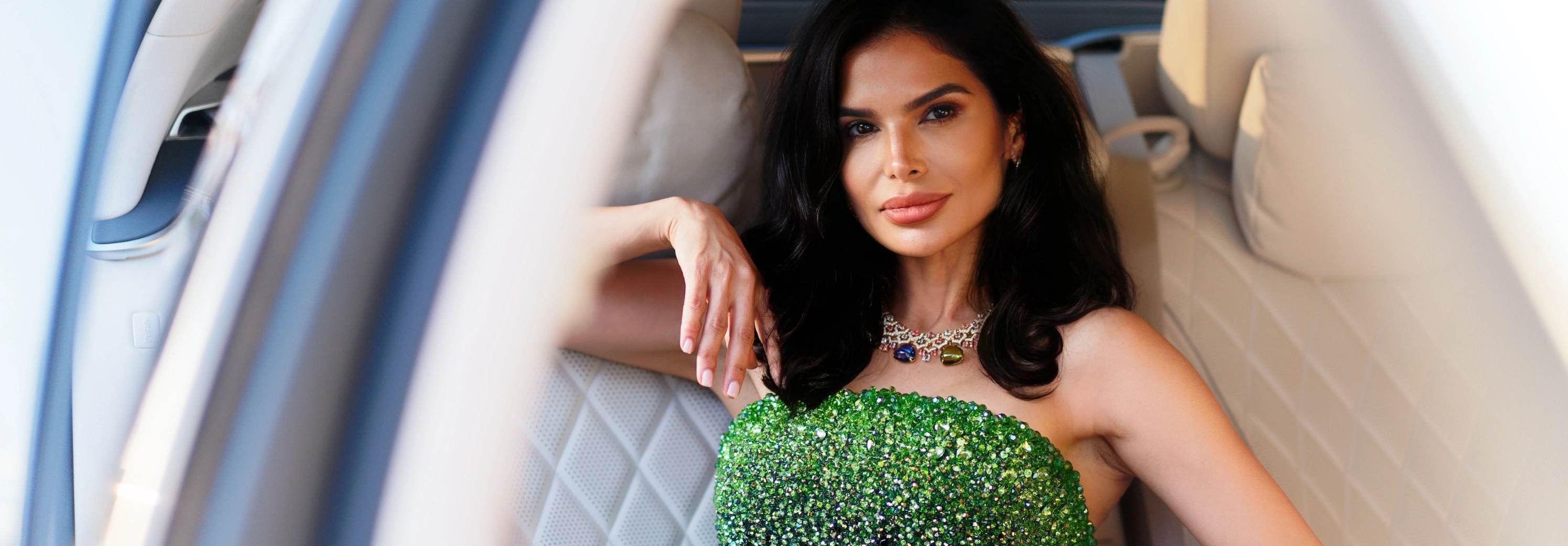 一位魅力四射的女士坐在一辆奔驰车的后座上。