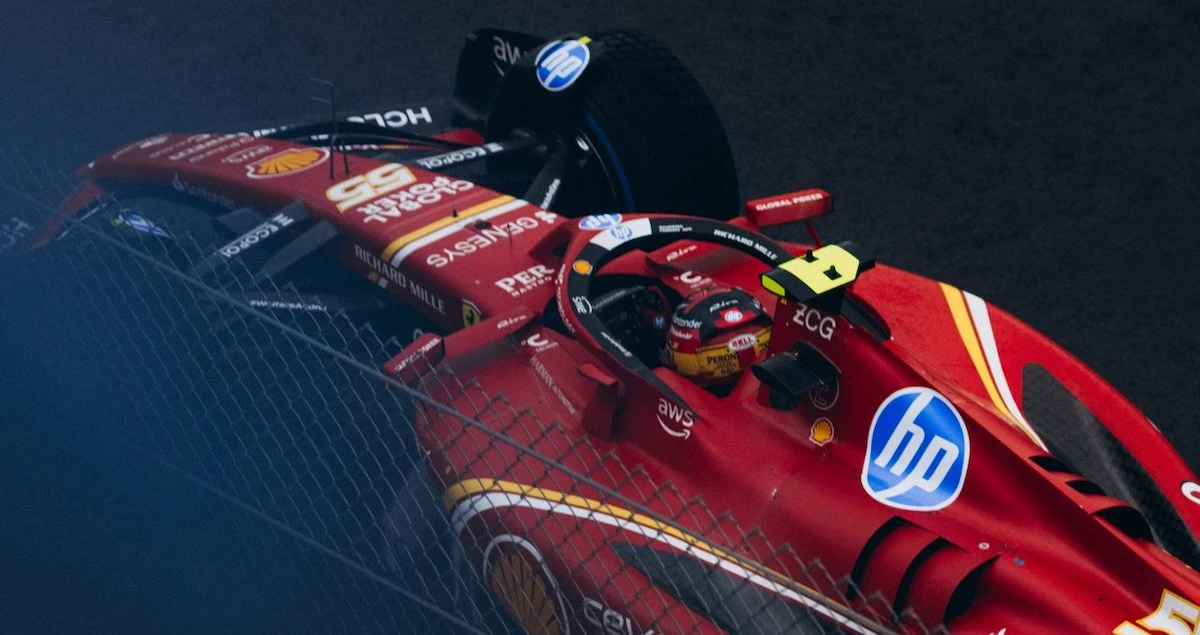 Close-up shot of a Ferrari F1 car competing in a night race on a track.