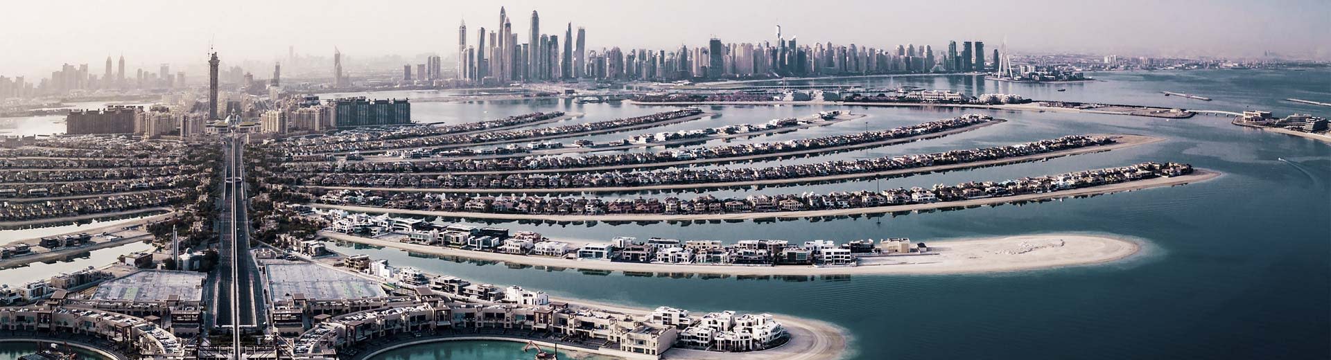 Dubais Palm Jumeirah, künstliche Inseln in Form von Palmwedeln, mit der Skyline des Kerns der Innenstadt im Hintergrund.