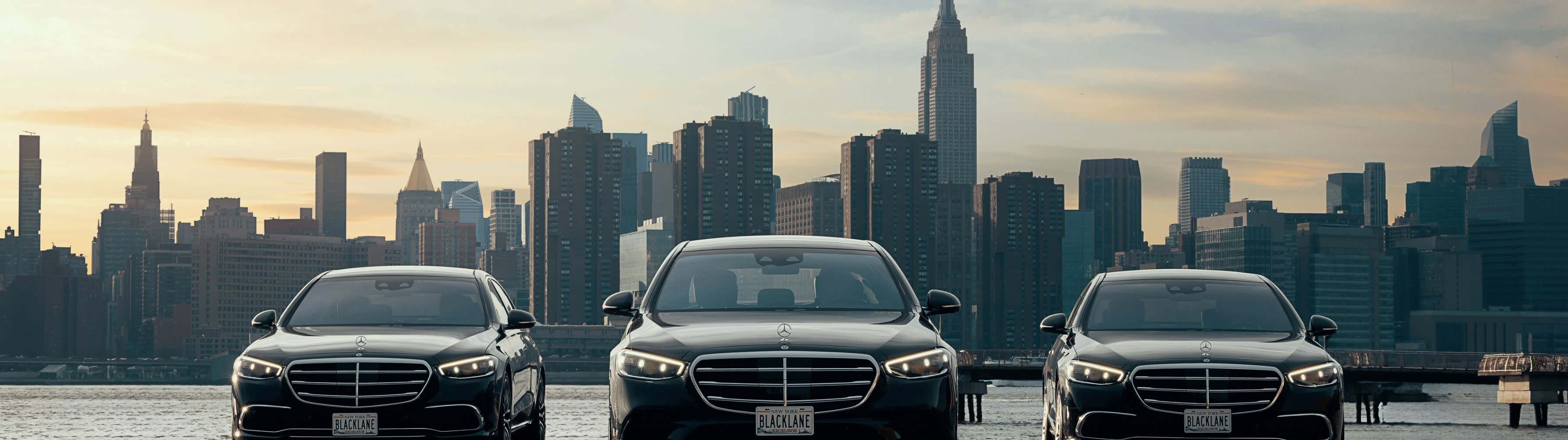 A Blacklane guests walks toward a Mercedes-Benz as the chauffeur holds the door open for her.