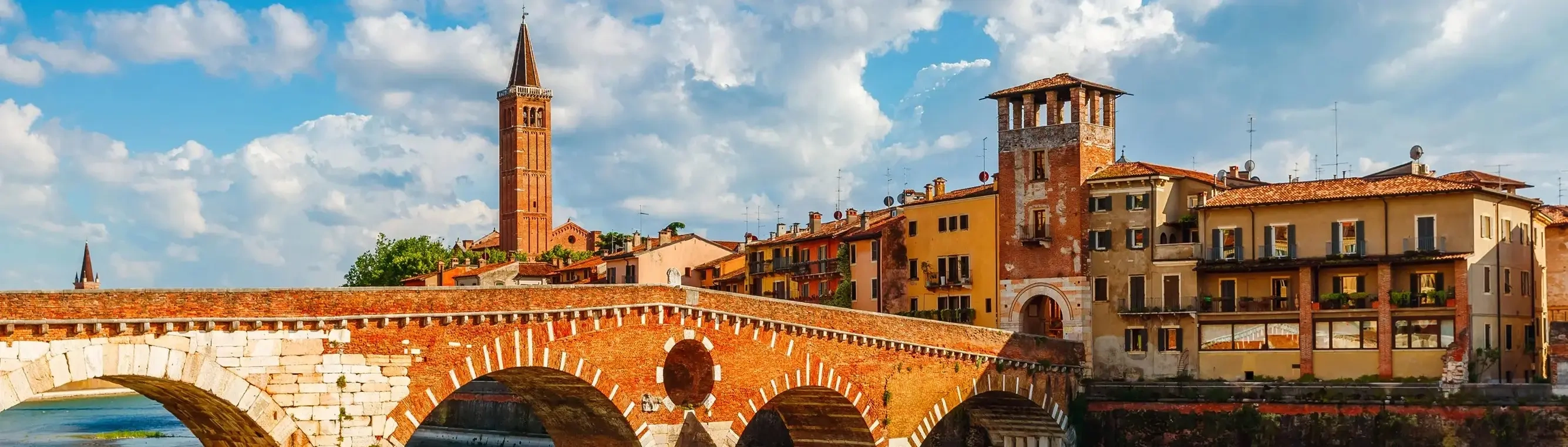 The ancient Ponte Pietra bridge over the River Adige in Verona, with the city in the background.