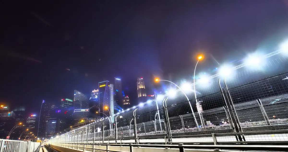 Close-up of the street race track of the Singapore Grand Prix, with the night-time skyscrapers in the background.