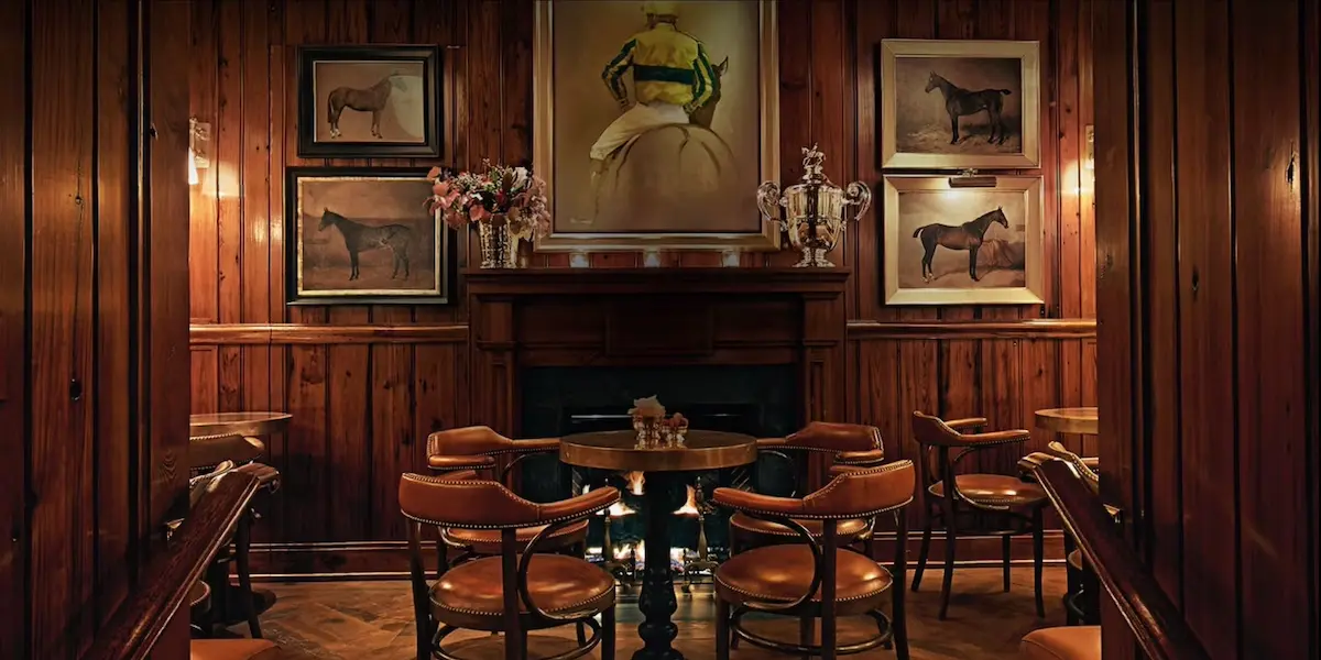 Interior shot of tables around a fireplace at the Ralph Lauren Polo Bar private dining room in NYC.