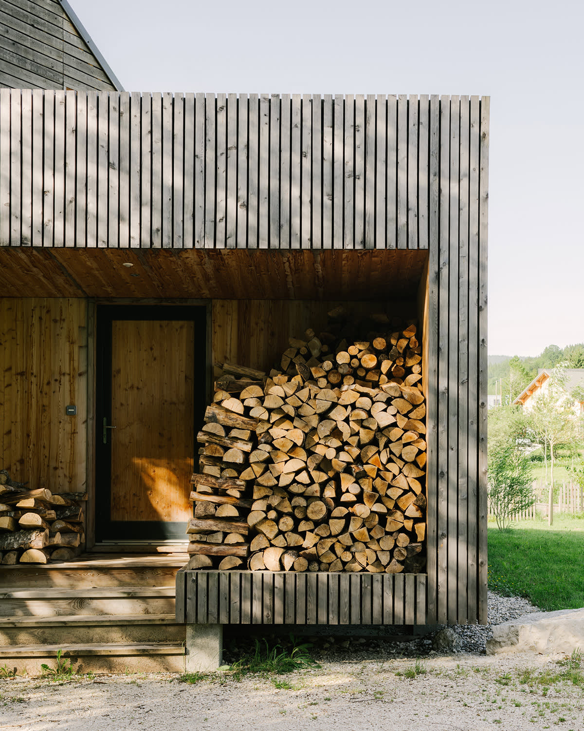 Bois de chauffage à l'entrée d'une maison en bois