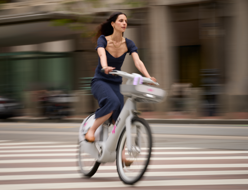 A woman rides an ebike through the city.