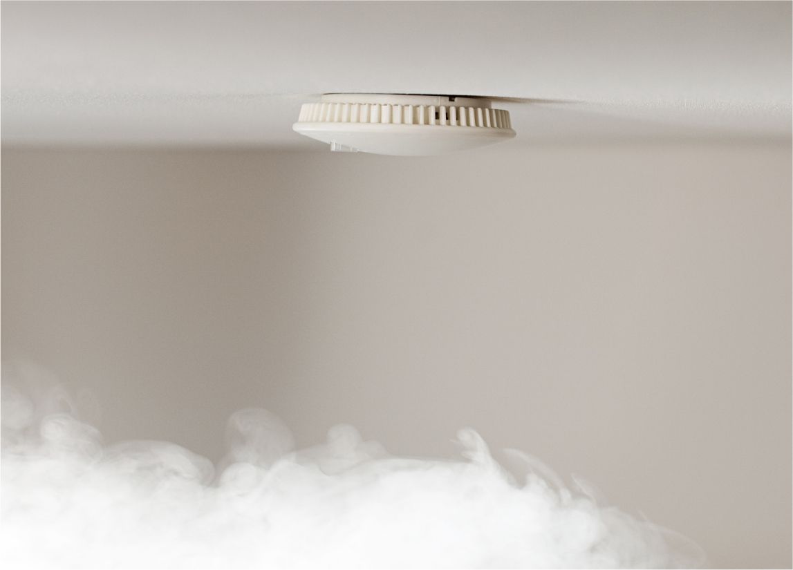 Smoke billowing toward smoke detector on ceiling
