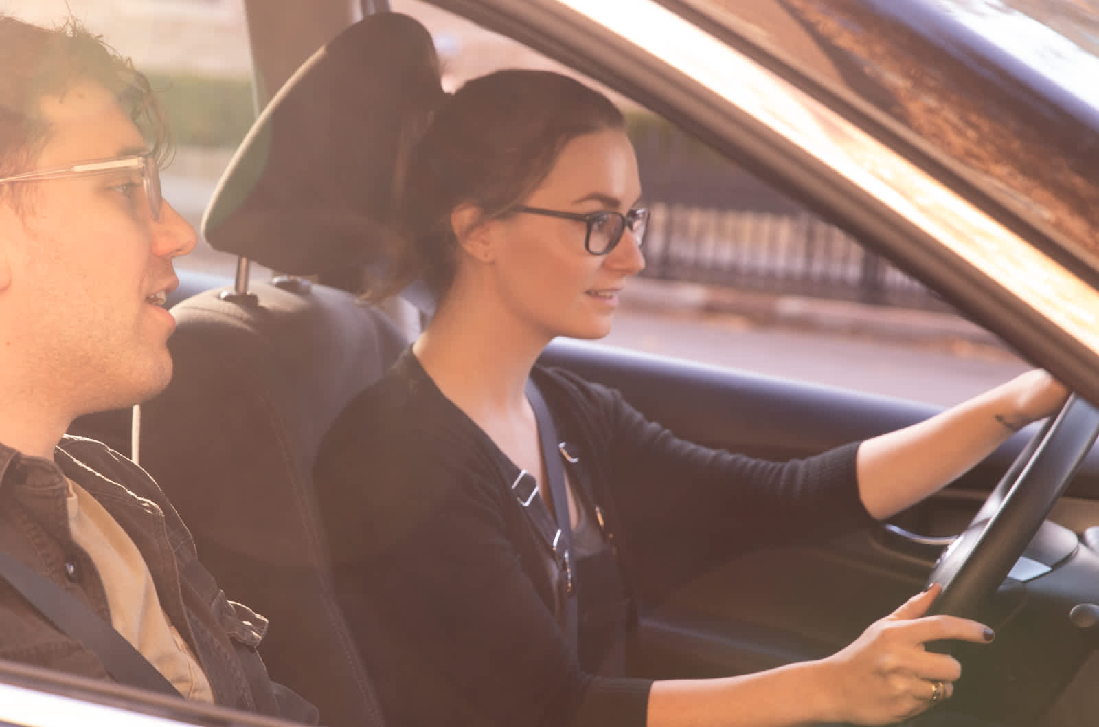 Woman with glasses has both hands on the wheel