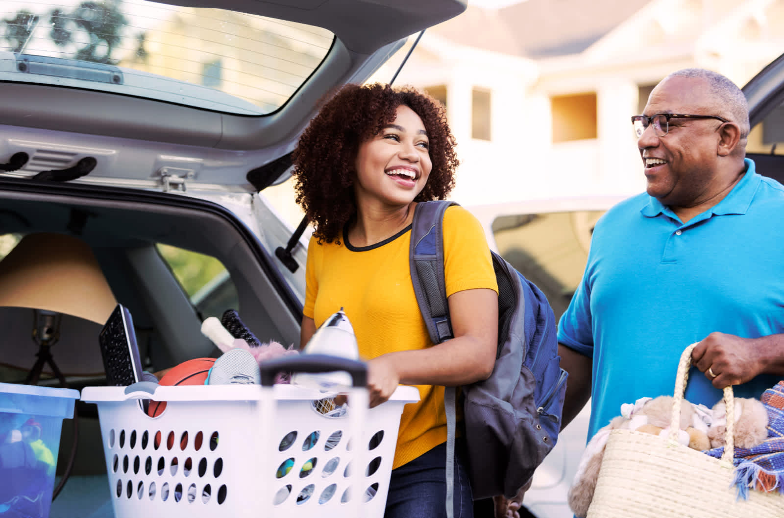 Father and daughter unload a car full of dorm gear