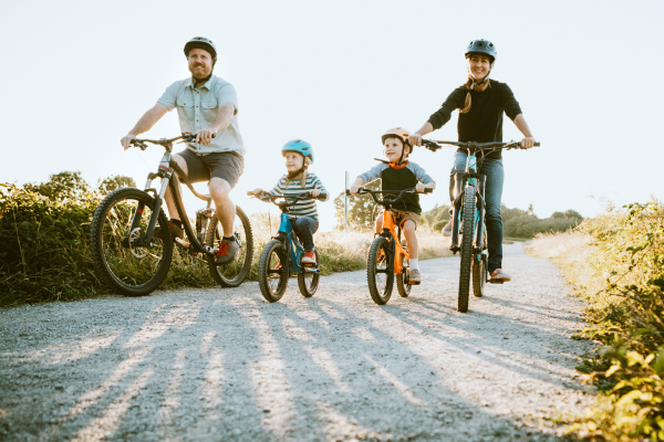 Family of four riding bikes in nature