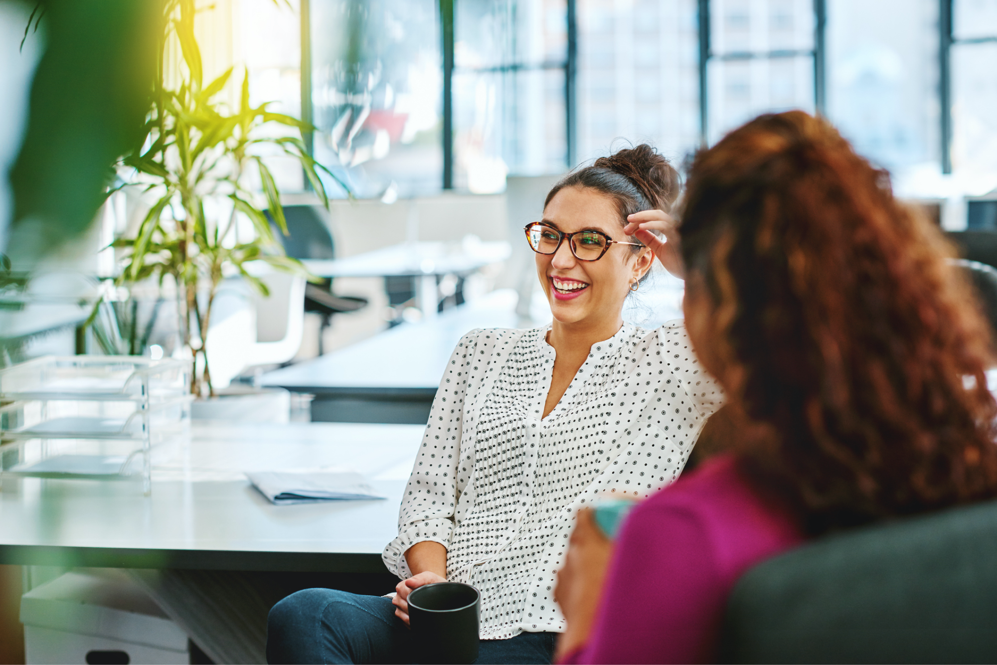 Woman laughing with colleagues in an office setting