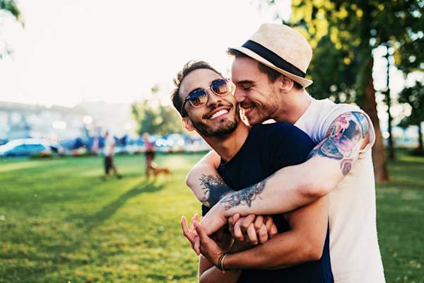young gay couple hanging out in the park