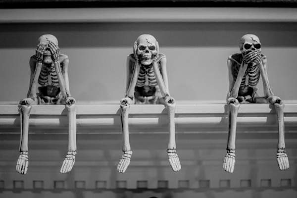 three human skeleton models doing "see no evil, hear no evil, speak no evil"