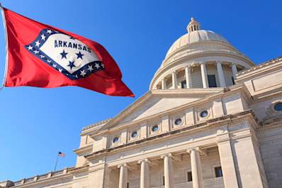 Arkansas flag flying high beside the State Capitol Building