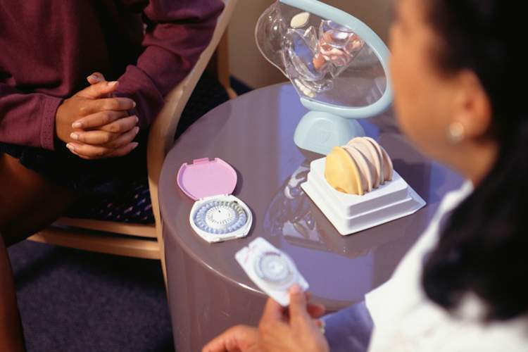 Nurse showing birth control options to patient