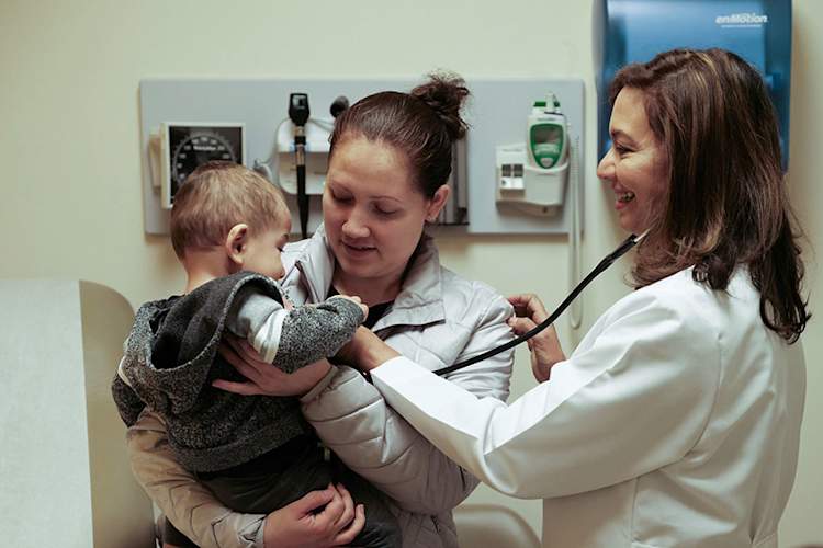Ligia Peralta caring for infant patient and mother